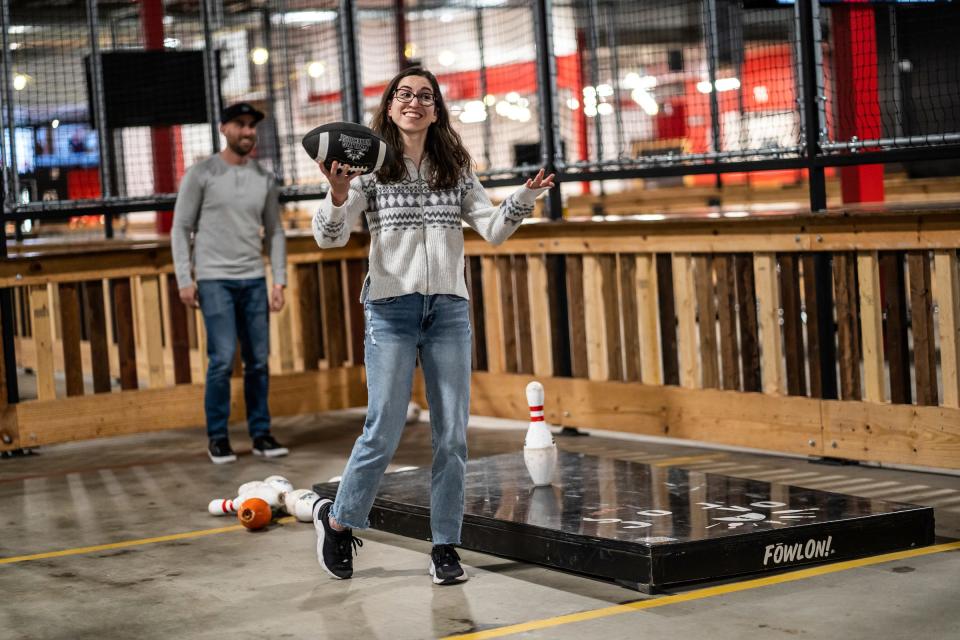 Katelyn Boisvert, of Ann Arbor, prepares to throw a football with teammate Wes Boisvert, of Portland, Oregon, during a game at the Fowling Warehouse in Ypsilanti on Friday, Nov. 3, 2023.