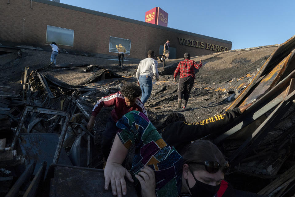 <strong>Minneapolis, May 30, 2020.</strong> People visit and take selfies on the collapsed roof of a Wells Fargo, destroyed in the riots and arson that followed the killing of George Floyd.<span class="copyright">Peter van Agtmael—Magnum Photos</span>