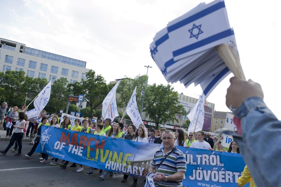 Participants of the March of The Living walk along at Blaha Lujza square to commemorate victims of the Holocaust in Budapest, Hungary, Sunday, April 27, 2014. It marks the 70th anniversary of the beginning of the Hungarian holocaust during which some 600 thousand Jewish Hungarians were deported to Nazi death camps. The banner reads: "About the past for the future" (AP Photo/MTI, Bea Kallos)
