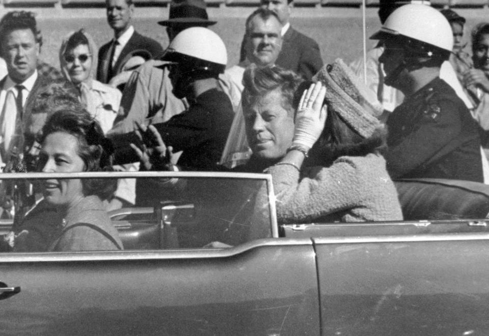 President John F. Kennedy waves from his car in a motorcade approximately one minute before he was shot in Dallas on Nov. 22, 1963. Riding with Kennedy are First Lady Jacqueline Kennedy, right, Nellie Connally, second from left, and her husband, Texas Gov. John Connally, far left. (Photo: Jim Altgens/AP)