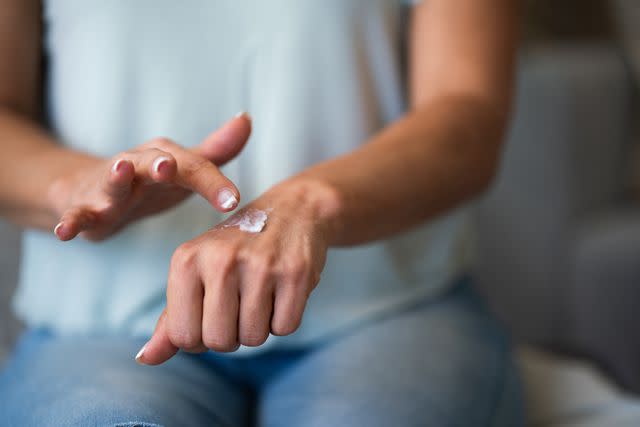 <p>StockPlanets / Getty Images</p> Close-up of female applying a cream to her hand