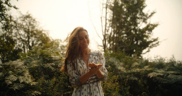 Kate holds a butterfly in her hands