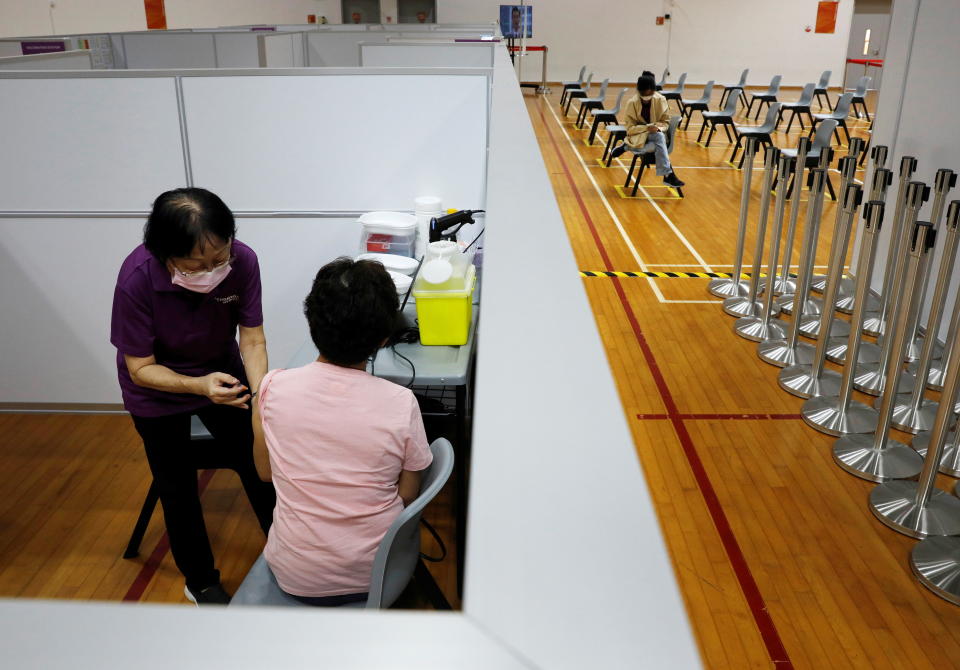 A woman receives her vaccination at a COVID-19 vaccination centre in Singapore.