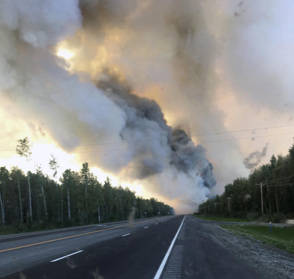 In this Sunday, Aug. 18, 2019 photo provided by the Alaska Division of Forestry, a smoke plume from the McKinley Fire is seen along the Parks Highway near Willow, Alaska. The main highway in Alaska that connects Anchorage and Fairbanks has reopened on a limited basis. A wildfire north of Willow jumped the Parks Highway on Sunday night, prompting a closure for a 9-mile stretch. The state Division of Forestry says one lane of traffic reopened at 8 a.m. Monday. (Maureen Clark/Alaska Division of Forestry via AP)