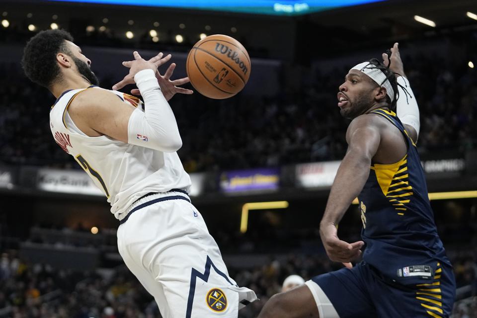 Indiana Pacers' Buddy Hield (7) knocks the ball from Denver Nuggets' Jamal Murray (27) during the first half of an NBA basketball game, Tuesday, Jan. 23, 2024, in Indianapolis. (AP Photo/Darron Cummings)