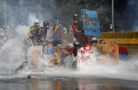 <p>Opposition supporters clash with riot security forces while rallying against President Nicolas Maduro in Caracas, Venezuela, May 18, 2017. The sign on top right reads “Honor is my badge.” (Marco Bello/Reuters) </p>