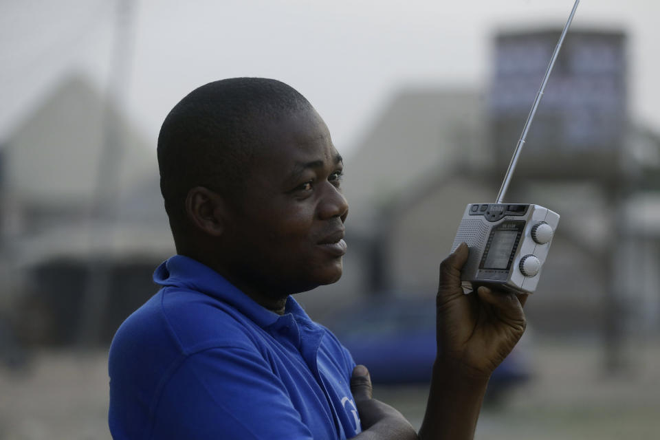 A man listen to a transistor radio at a polling station following the presidential election being delayed by the Independent National Electoral Commission in Yola, Nigeria, Saturday, Feb. 16, 2019. A civic group monitoring Nigeria's now-delayed election says the last-minute decision to postpone the vote a week until Feb. 23 "has created needless tension and confusion in the country." (AP Photo/Sunday Alamba)