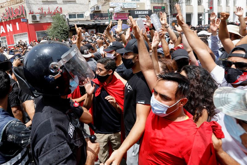 Manifestantes se reúnen frente a agentes de policía durante una protesta contra el gobierno en Túnez