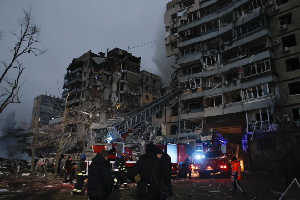 Emergency workers clear the rubble after a Russian rocket hit a multistory building leaving many people under debris in Dnipro, Ukraine, Saturday, Jan. 14, 2023. (AP Photo/Roman Chop)