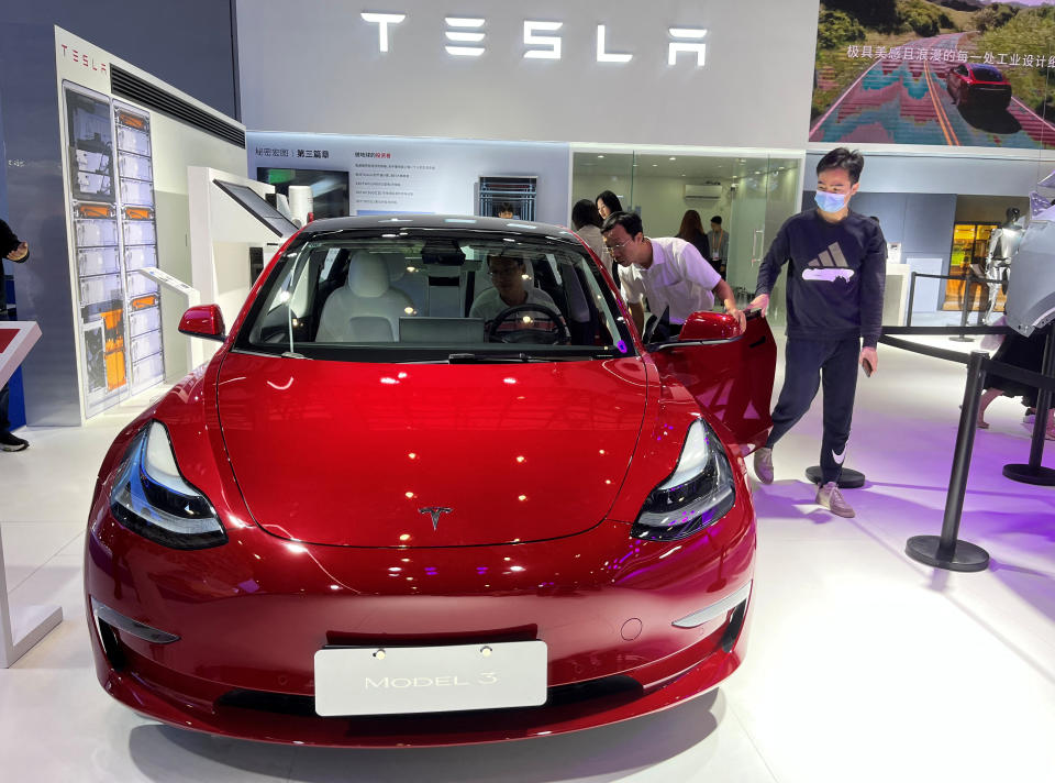 Visitors look at a Tesla Model 3 electric vehicle (EV) at the third China International Consumer Products Expo, in Haikou, Hainan province, China April 12, 2023. REUTERS/Casey Hall