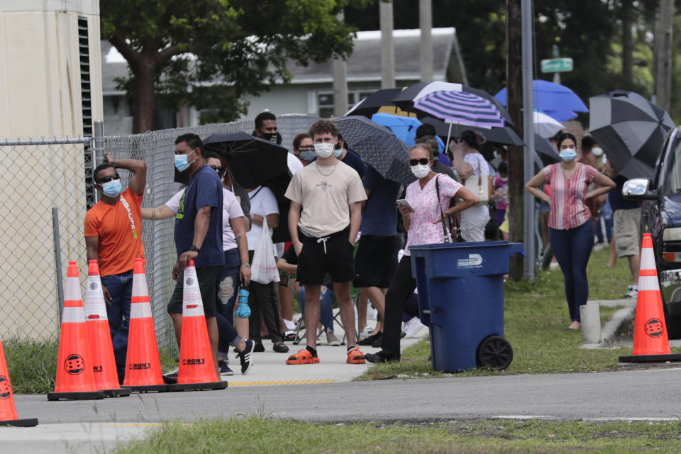 People wait in line outside of a COVID-19 testing site during the coronavirus pandemic, Thursday, July 16, 2020, in Opa-locka, Fla. (AP Photo/Lynne Sladky)