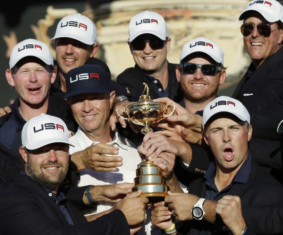 <p>United States captain Davis Love III is surrounded by his players as they pose for a picture during the closing ceremony of the Ryder Cup golf tournament Sunday, Oct. 2, 2016, at Hazeltine National Golf Club in Chaska, Minn. (AP Photo/David J. Phillip) </p>