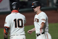 San Francisco Giants' Alex Dickerson, right, is congratulated by Evan Longoria (10) after scoring on a sacrifice fly by Brandon Crawford during the fifth inning against the Colorado Rockies in a baseball game Wednesday, Sept. 23, 2020, in San Francisco. (AP Photo/Tony Avelar)