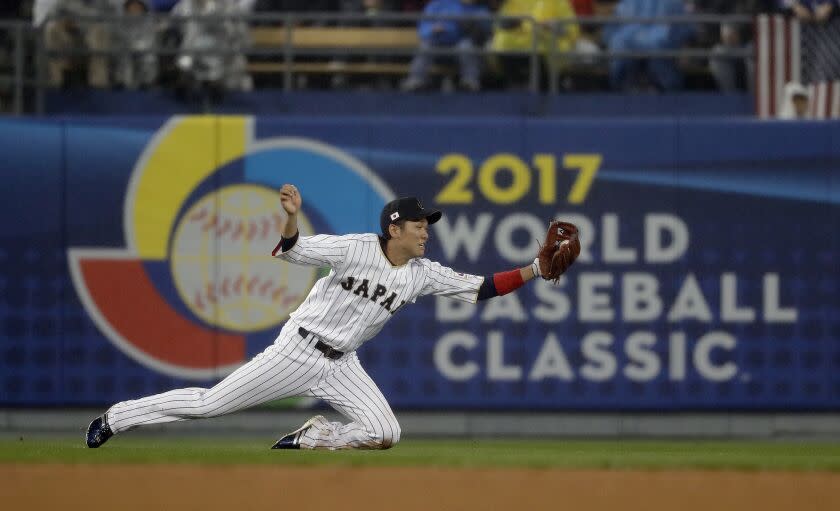 FILE - In this March 21, 2017, file photo, Japan's Hayato Sakamoto makes a catch on a ball hit by United States' Buster Posey during the fourth inning of a semifinal in the World Baseball Classic in Los Angeles. The World Baseball Classic will be postponed from 2021 to 2023 because of the new coronavirus, a person familiar with the planning tells The Associated Press. The person spoke on condition of anonymity Monday, May 11, 2020, because no announcement had been made. (AP Photo/Chris Carlson, File)
