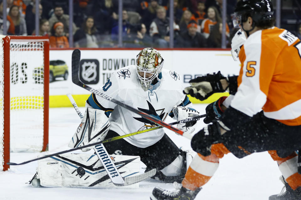 San Jose Sharks' Aaron Dell (30) blocks a shot by Philadelphia Flyers' Philippe Myers (5) during the second period of an NHL hockey game, Tuesday, Feb. 25, 2020, in Philadelphia. (AP Photo/Matt Slocum)