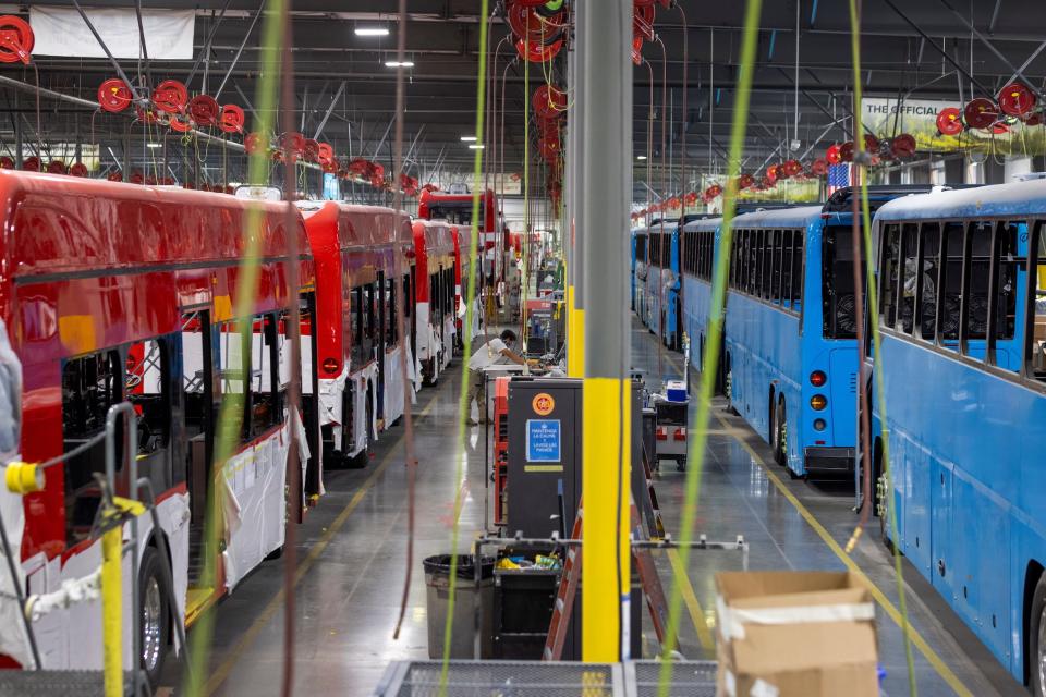 electric buses lined up inside factory