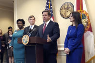 Florida Gov. Ron DeSantis speaks during a news conference as Deputy Secretary for Health Dr. Shamarial Roberson, left, Florida Surgeon General Dr. Scott Rivkees, second from left, and Lt. Gov. Jeanette Nuñez, right, listen, Thursday, Feb. 27, 2020, in Tallahassee, Fla. DeSantis attempted to reassure his state Thursday that health officials were prepared for any cases of a new virus that has killed thousands worldwide, saying there were no confirmed cases — yet — of infections from COVID-19. (AP Photo/Bobby Caina Calvan)