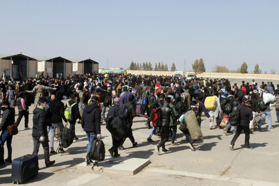 FILE - In this Wednesday, March 18, 2020 file photo, thousands of Afghan refugees walk as they enter Afghanistan at the Islam Qala border crossing with Iran, in the western Herat Province. Some 200,000 Afghans and counting have returned from Iran to their home country after losing their jobs in the coronavirus pandemic or out of fear of getting infected. They are flowing across the border from a country that has one of the world's worst outbreak to an impoverished nation that is woefully unprepared to deal with the virus. (AP Photo/Hamed Sarfarazi, File)