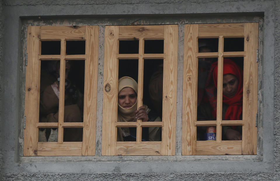 Kashmiri women watch the funeral of killed rebel Khalid Farooq, in Shopian village, south of Srinagar, Indian controlled Kashmir, Sunday, Nov. 25, 2018. Six rebels and an army soldier were killed in a gunbattle in Indian-controlled Kashmir on Sunday, officials said, sparking violent protests by residents seeking an end to Indian rule over the disputed region and leaving a teenage boy dead and 20 people injured. (AP Photo/Mukhtar Khan)
