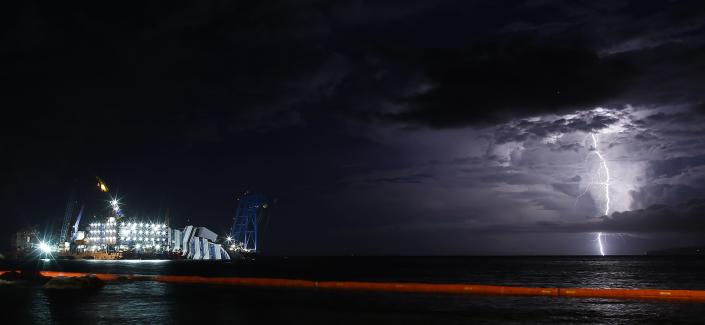 A lightning storm is pictured over the sea near the capsized cruise liner Costa Concordia, outside Giglio harbour September 15, 2013. (REUTERS/Tony Gentile)