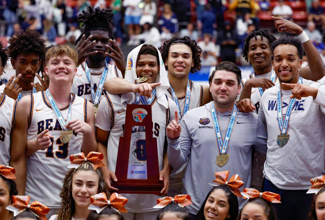 Mater Lakes Academy’s Michale Bradley (0) holding the State Championship Trophy celebrates with teammates after defeating The Villages Charter during the FHSAA Class 4A State Championship at the RP Funding Center in Lakeland, Florida on Saturday, March 4, 2023.