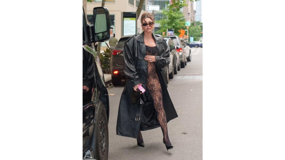 Hailey rocked a risqué lace catsuit, leather trench and heels