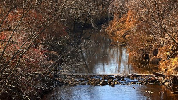 PHOTO: In this Dec. 9, 2021, file photo, water flows in Coldwater Creek behind a row of homes at Belcroft Drive and Old Halls Ferry Road in Missouri's St. Louis County. (Christian Gooden/St. Louis Post-Dispatch via AP, FILE)