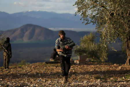 A Turkish-backed Free Syrian Army fighter carries a military binoculars north of the city of Afrin, Syria February 18, 2018. REUTERS/Khalil Ashawi