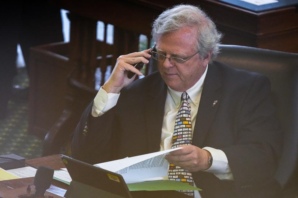 Sen. Paul Bettencourt looks through paperwork and talks on the phone during a hearing at the Capitol on Thursday in Austin. Bettencourt, R-Houston, introduced Senate Bills 3 and 4, which passed unanimously Wednesday out of the Senate Finance committee.