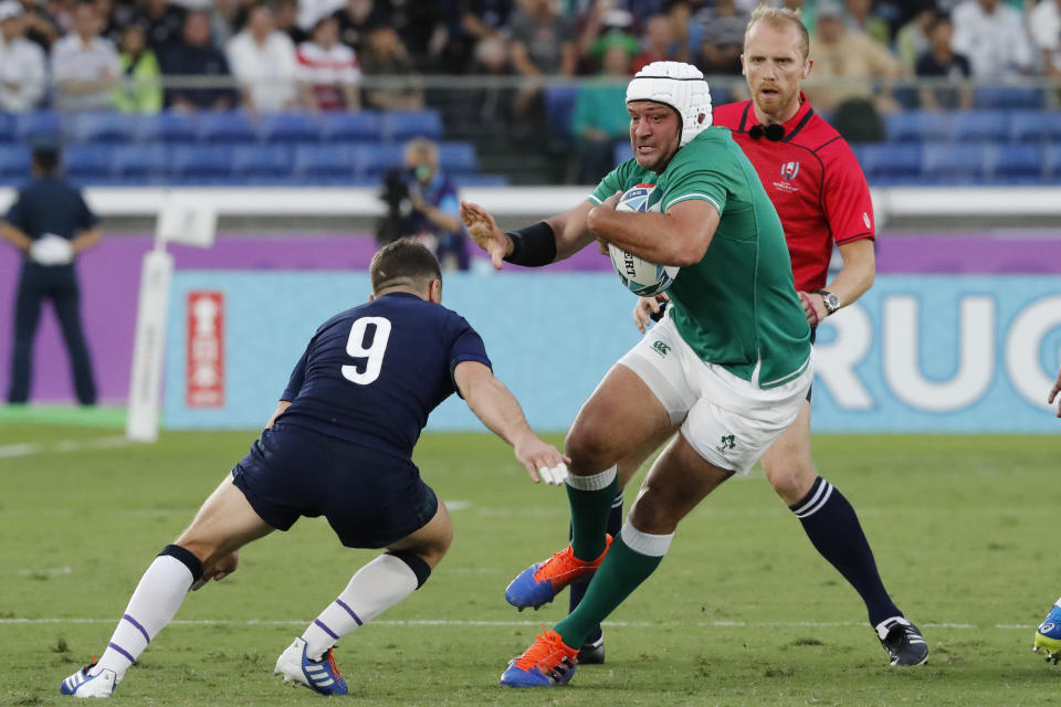 Ireland's Rory Best, center, runs at Scotland's Greig Laidlaw during the Rugby World Cup Pool A game at International Stadium between Ireland and Scotland in Yokohama, Japan, Sunday, Sept. 22, 2019. (AP Photo/Eugene Hoshiko)