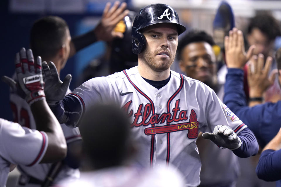 Atlanta Braves' Freddie Freeman is congratulated in the dugout after hitting a two-run home run during the fifth inning of a baseball game against the Miami Marlins, Saturday, July 10, 2021, in Miami. (AP Photo/Lynne Sladky)