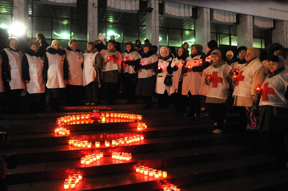 Ukrainian people make a red ribbon sign with candles ahead of the World AIDS Day, in Kiev, Ukraine, Thursday, Nov. 29, 2012. (AP Photo / Sergei Chuzavkov)