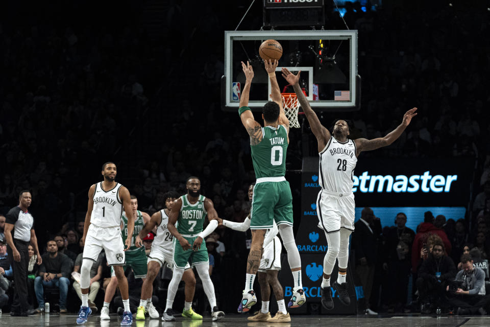 Boston Celtics forward Jayson Tatum (0) shoots against Brooklyn Nets forward Dorian Finney-Smith (28) during the first half of an NBA basketball game in New York, Tuesday, Feb. 13, 2024. (AP Photo/Peter K. Afriyie)