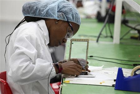 A worker assembles Android-based tablets from imported components at the Surtab factory in the Sonapi Industrial Park of Port-au-Prince March 11, 2014. REUTERS/Marie Arago