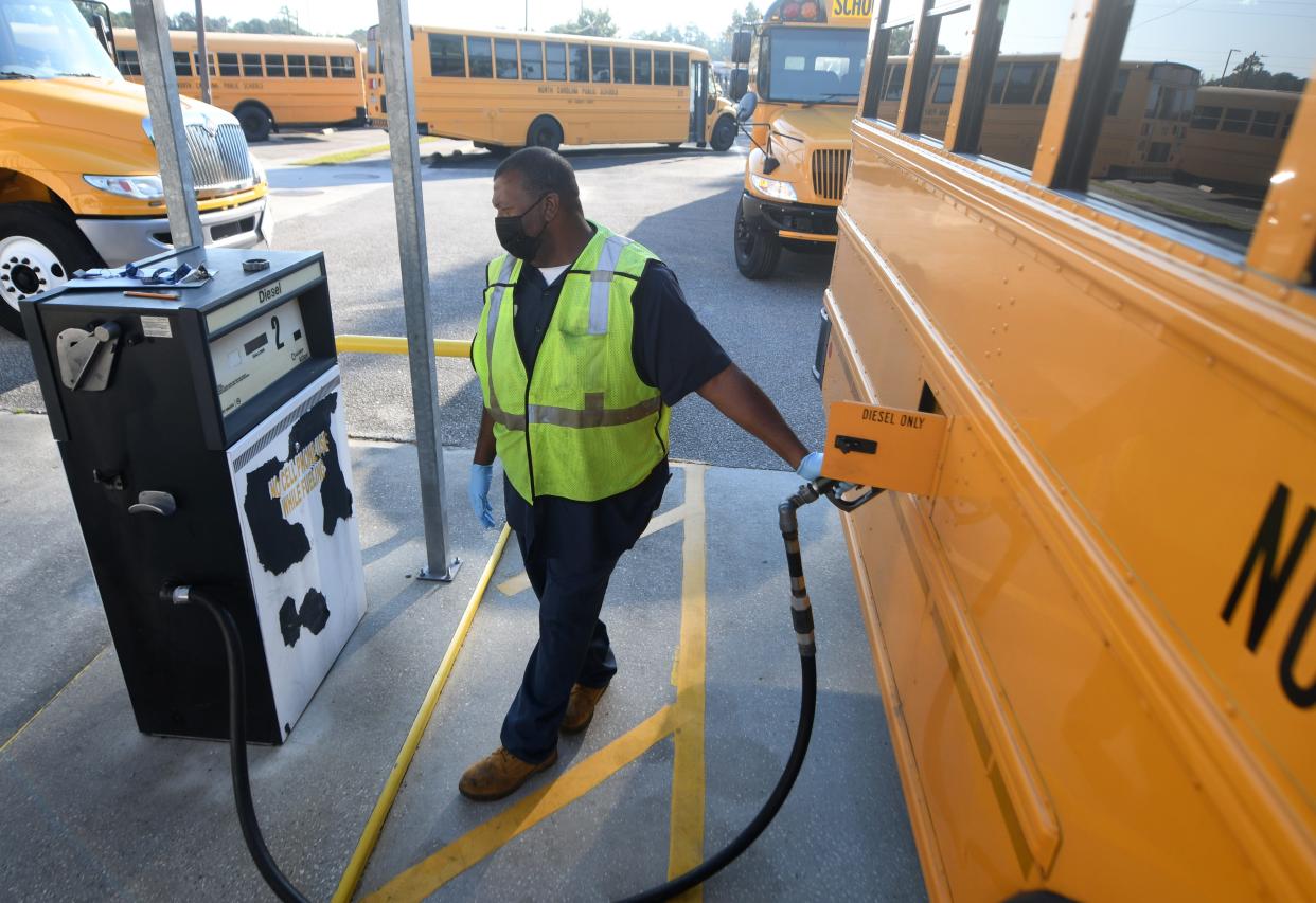 Marvin Tomlin, a mechanic with New Hanover County Schools, fills up a bus with gas at the county's main bus lot in Wilmington, N.C, Wednesday, Sept. 29, 2021.