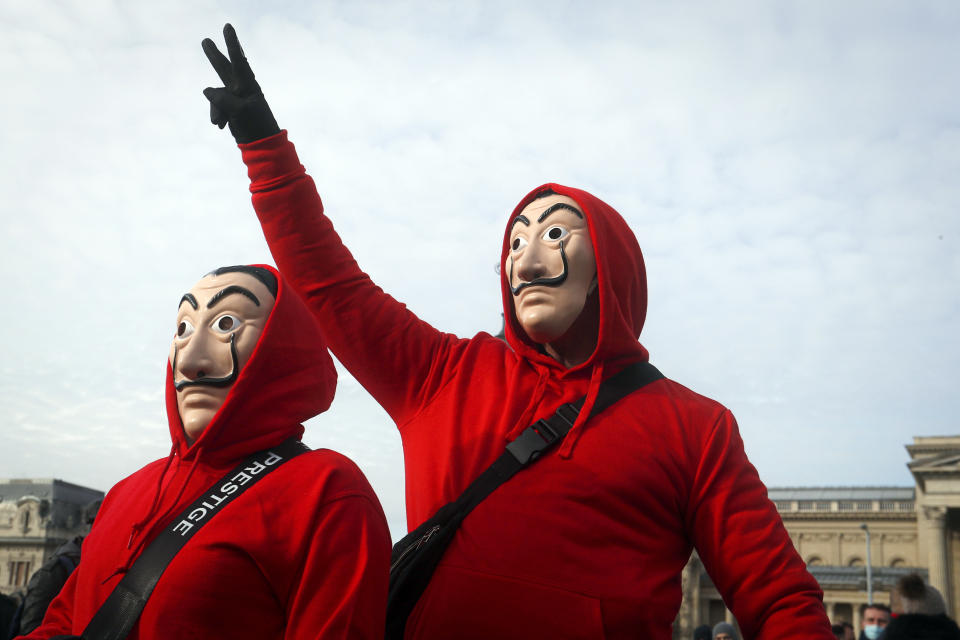 People wearing masks take part in a hospitality sector workers protest, in Budapest, Hungary, Sunday, Jan. 31, 2021. Protesters gathered at a central square in Hungary's capital of Budapest on Sunday demanding a rethinking of the country's lockdown restrictions. As the lockdown limiting restaurants to take-away service approaches the three-month mark, many business owners complain that they have received little to none of the government’s promised financial assistance while other businesses like shopping malls and retail stores have been permitted to remain open. (AP Photo/Laszlo Balogh)