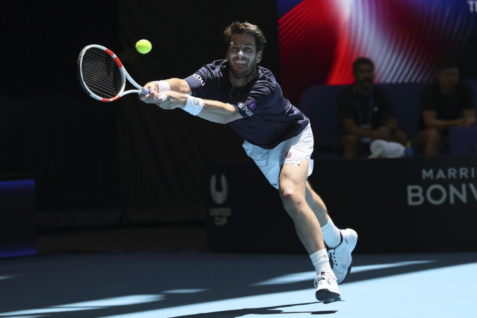 Cameron Norrie of Britain reaches for a backhand shot to Taylor Fritz of the United States during the United Cup tennis tournament in Perth, Australia, Sunday, Dec. 31, 2023. (AP Photo/Trevor Collens)