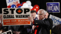 <p>Republican presidential hopeful Sen. John McCain, R-Ariz., holds up a climate change awareness poster as he speaks at a campaign rally in Portsmouth, N.H., Jan. 7, 2008. (Photo: Charles Dharapak/AP) </p>