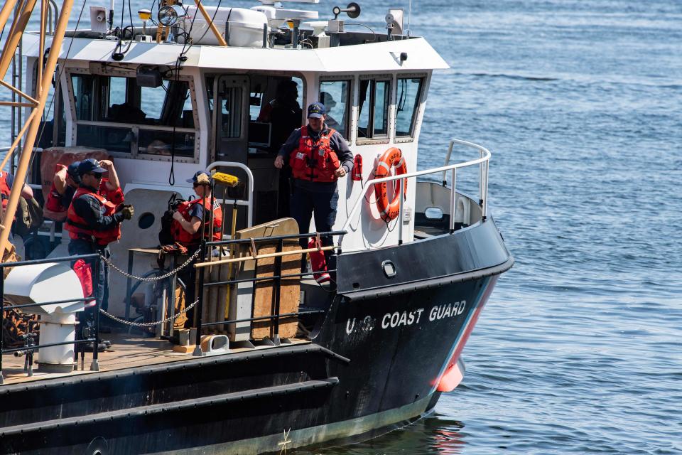 Crews work on Coast Guard vessels at Coast Guard Base Boston in Boston on Wednesday. Rescuers searching for the submersible near the wreck of the Titanic have detected "underwater noises" in the search area, the U.S. Coast Guard said.