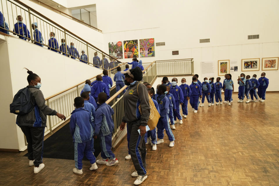 Schoolchildren join a queue to see paintings done in the 1940s and 1950s by young Black students at Cyrene Mission School at the National Gallery of Zimbabwe, Wednesday Aug. 3, 2022. The paintings are part of a historic exhibit, "The Stars are Bright," now showing in Zimbabwe for the first time since the collection left the country more than 70 years ago. (AP Photo/Tsvangirayi Mukwazhi)