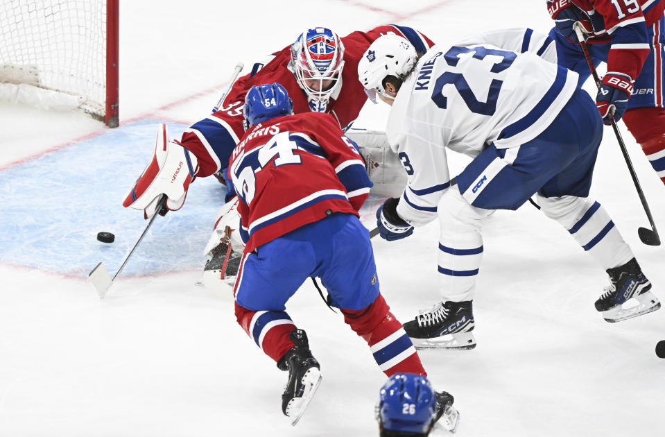 Toronto Maple Leafs' Matthew Knies (23) scores against Montreal Canadiens goaltender Sam Montembeault as Canadiens' Jordan Harris (54) defends during the second period of an NHL hockey game in Montreal, Saturday, April 6, 2024. (Graham Hughes/The Canadian Press via AP)