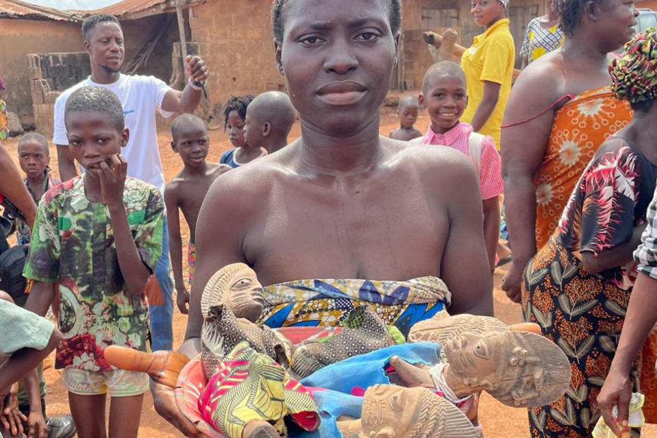 A woman hold figurines used at the shrine for twin gods in Igbo-Ora, Nigeria