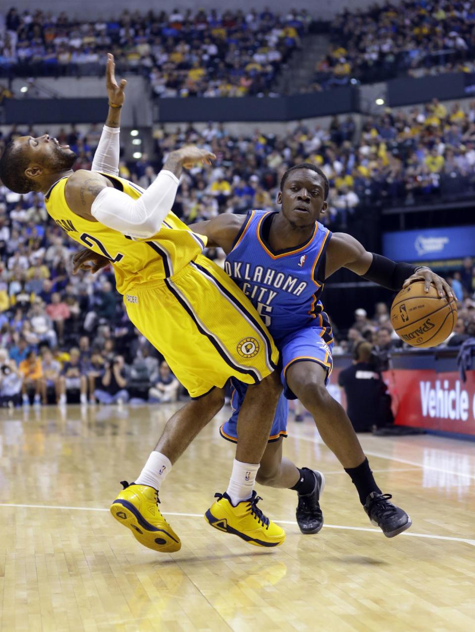 Indiana Pacers guard C.J. Watson, left, draws an offensive foul from Oklahoma City Thunder guard Reggie Jackson in the second half of an NBA basketball game in Indianapolis, Sunday, April 13, 2014. (AP Photo/Michael Conroy)