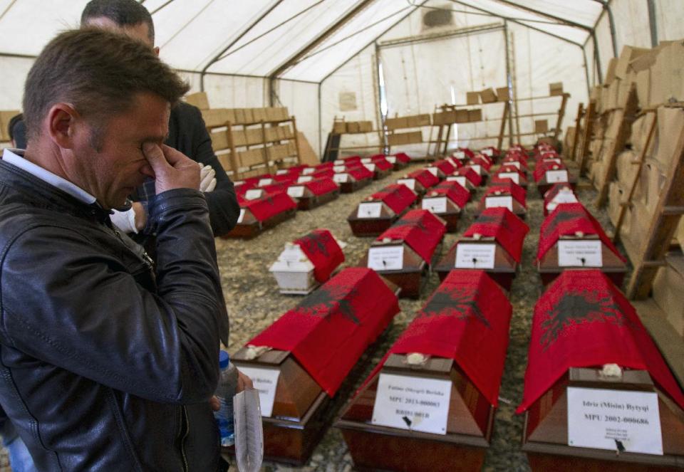 A relative weeps as 46 coffins, draped with Albanian flags, containing the remains of ethnic Albanians killed during the 1998-99 Kosovo war, are handed over to family members in capital Pristina on Monday, March 24, 2014. The victims were killed in two separate rampages by Serbs forces in western Kosovo just days after NATO began a bombing campaign to stop Serbia’s onslaught on separatist ethnic Albanians on March 1999. (AP Photo/Visar Kryeziu)