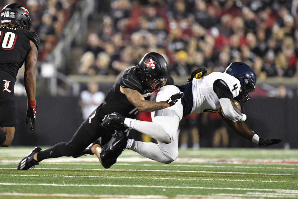 Louisville defensive back Cam'Ron Kelly (11) brings down Murray State running back Cortezz Jones (4) during the first half of an NCAA college football game in Louisville, Ky., Thursday, Sept. 7, 2023. (AP Photo/Timothy D. Easley)