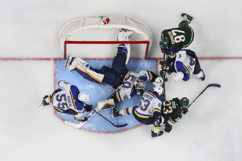 St. Louis Blues goaltender Jordan Binnington makes a save while defenseman Colton Parayko (55), left wing Jake Neighbours (63), defenseman Nick Leddy (4), Minnesota Wild center Marco Rossi (23) and left wing Kirill Kaprizov (97) defend during the second period of an NHL hockey game, Tuesday, Nov. 28, 2023, in St Paul, Minn. (AP Photo/Matt Krohn)