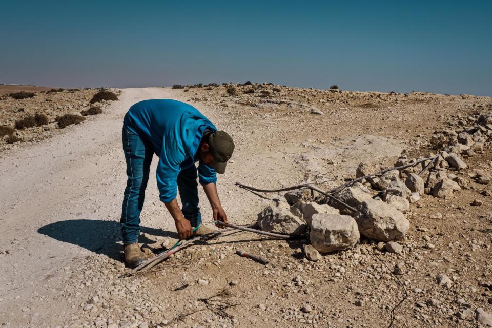 Awad Ibrahim Ali Awad inspects the damage to the severed power lines that provide electricity to nearby Palestinian villages.