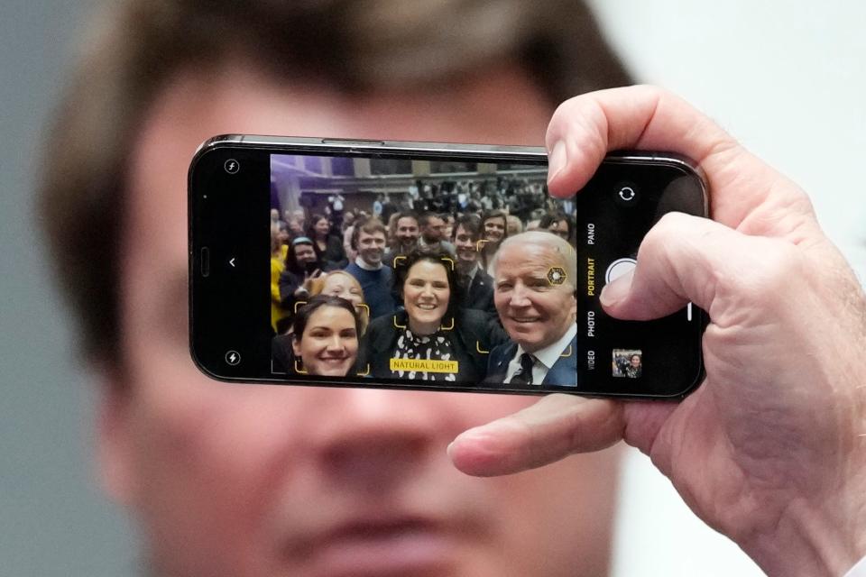President Joe Biden holds a cellphone as he takes a picture with a members of the audience after making a speech about Northern Ireland's vast economic potential at the Ulster University's new campus in Belfast, Northern Ireland, Wednesday, April 12, 2023.