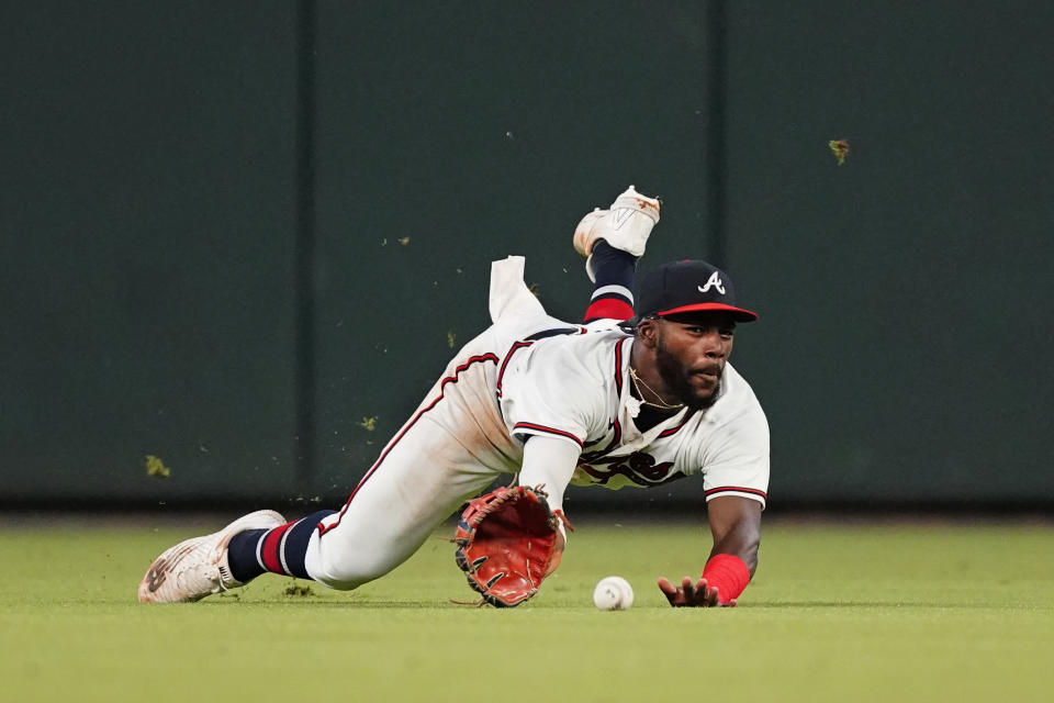 Atlanta Braves center fielder Michael Harris II makes a diving attempt for a ball hit for a triple by Colorado Rockies' Brendan Rodgers during the fourth inning of a baseball game Tuesday, Aug. 30, 2022, in Atlanta. (AP Photo/John Bazemore)