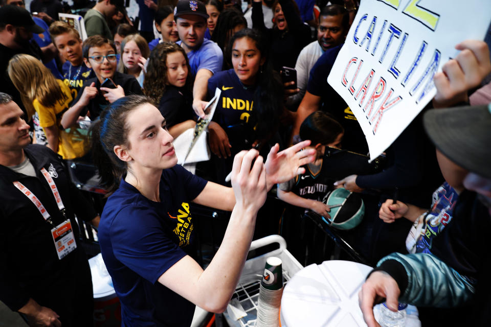 FILE - Indiana Fever guard Caitlin Clark signs autographs for fans before the start of WNBA basketball game against the New York Liberty, Saturday, May 18, 2024, in New York. (AP Photo/Noah K. Murray, File)
